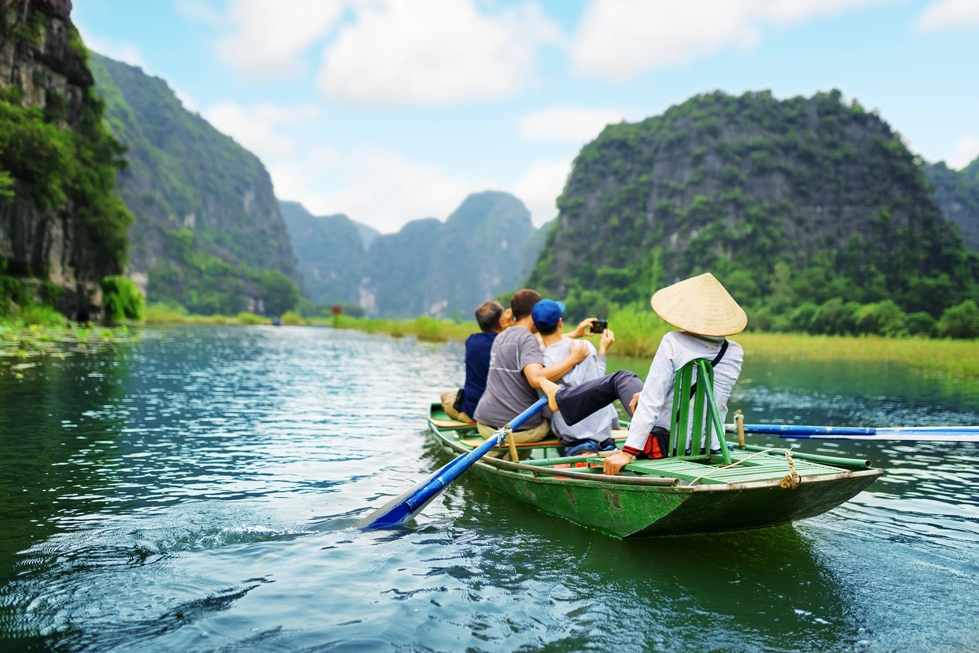 VIETNAM_Tourists_traveling_in_boat_along_the_Ngo_Dong_River_and_taking_picture_of_the_Tam_Coc__Ninh_Binh__Vietnam